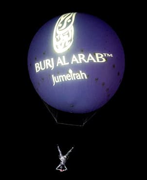 Helium balloon branded with the Burj Al Arab Jumeirah logo with an aerialist suspended beneath