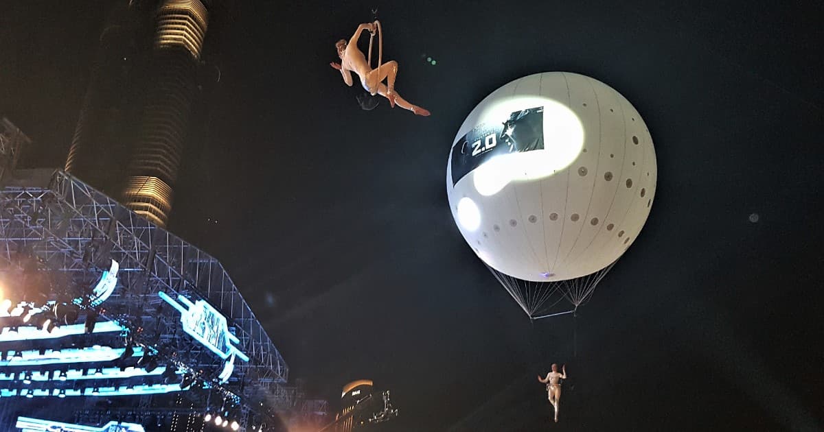 Two aerialists performing beneath a projection-lit helium balloon at the 2.0 film audio launch in Burj Park, Dubai